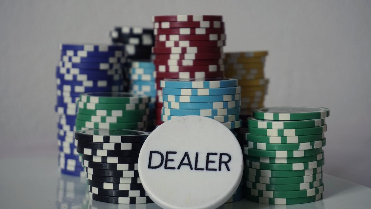 Pokermarker och en dealer-knapp på ett kasinogolv